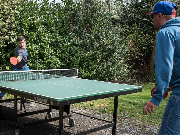 Jugendliche beim Tischtennis spielen auf der Terasse