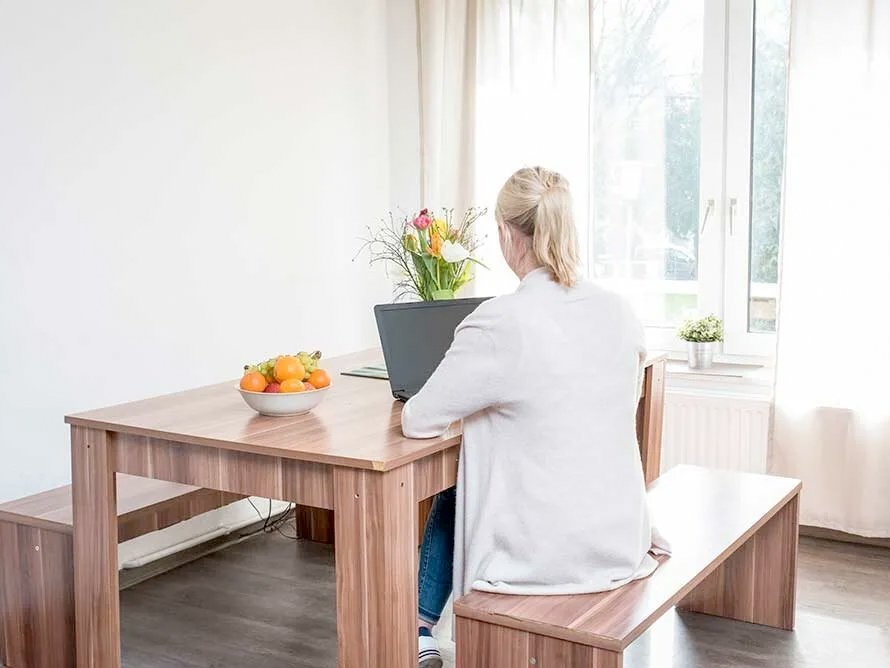 Frau am Laptop - am Tisch sitzend von hinten Fotografiert 