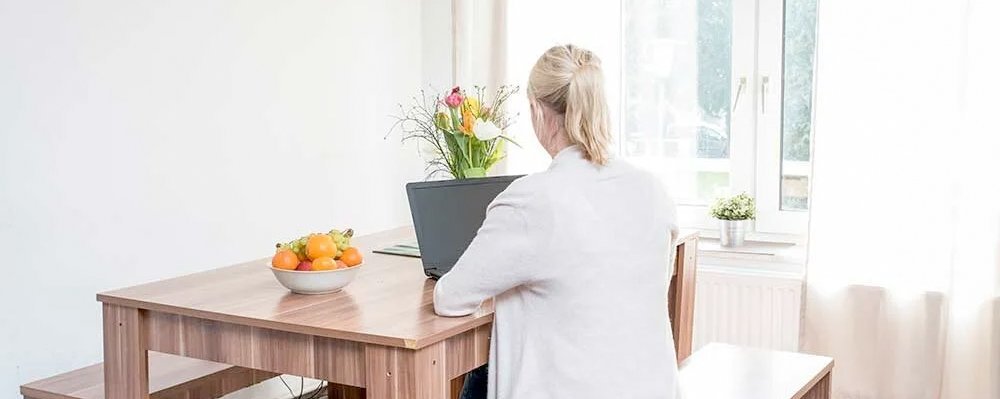 Frau am Laptop - am Tisch sitzend von hinten Fotografiert 