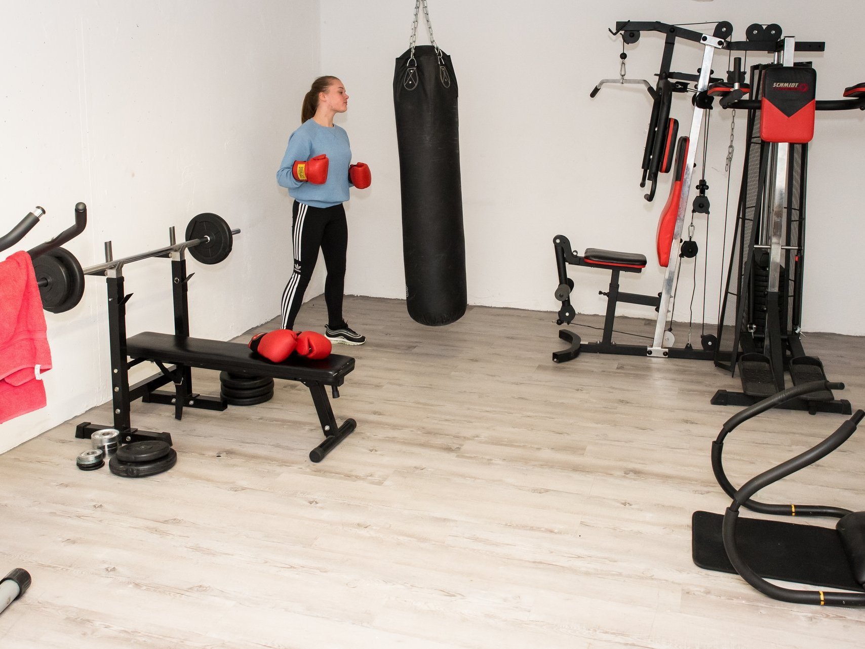 Mädchen beim Boxtraining am Sandsack im Fitnessraum